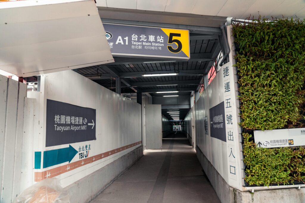 首頁 Covered walkway leading to Taipei Main Station Exit 5 with signs to Taoyuan Airport MRT.
