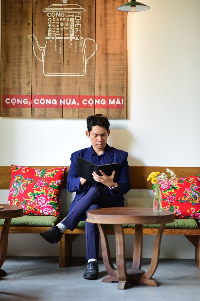 testimonial A businessman reading a menu in an indoor café with vibrant decor and floral accents.